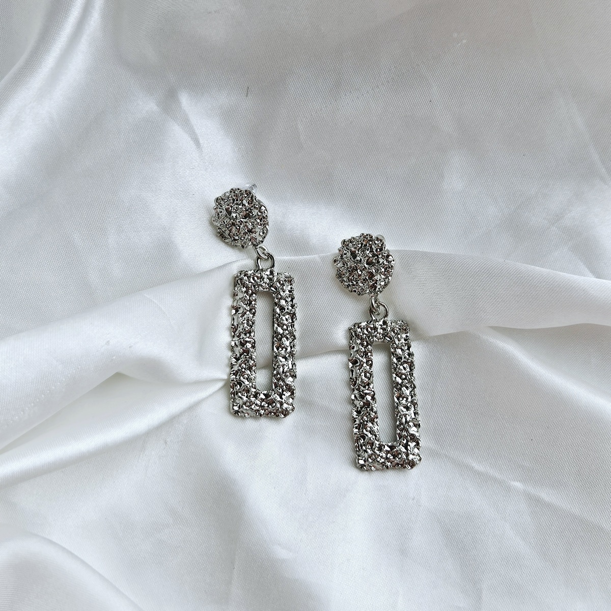 Sidabro spalvos puošnūs auskarai